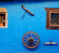 Parete azzurra con ruota di carro e oggetti vari