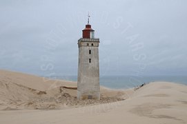 Faro bianco tra le dune di sabbia della spiaggia